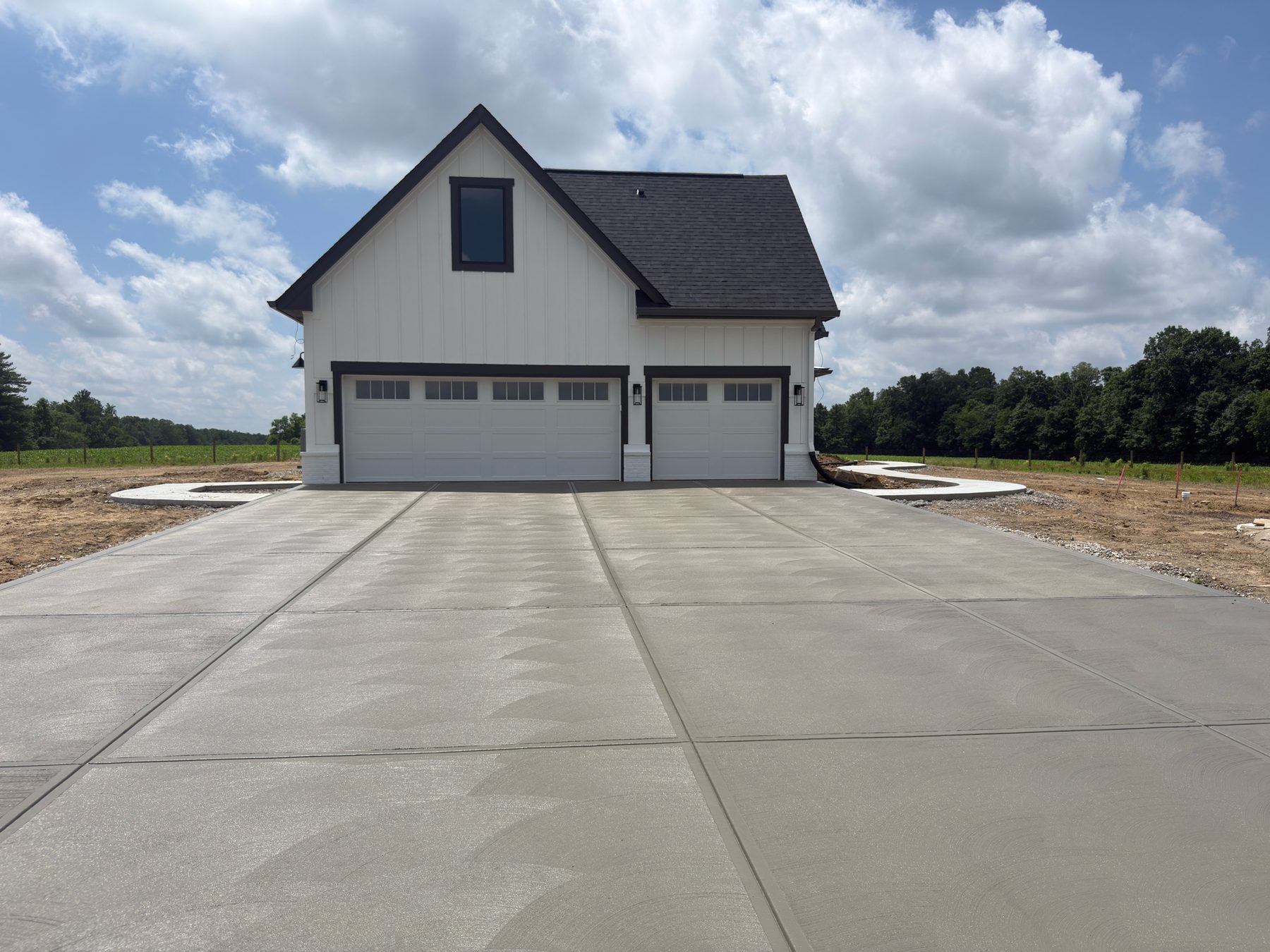 Finished broom-finish concrete driveway in front of a home